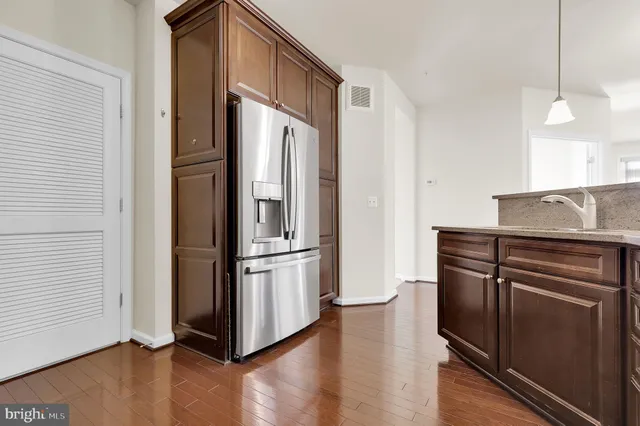 a kitchen with stainless steel appliances granite countertop a refrigerator and a stove