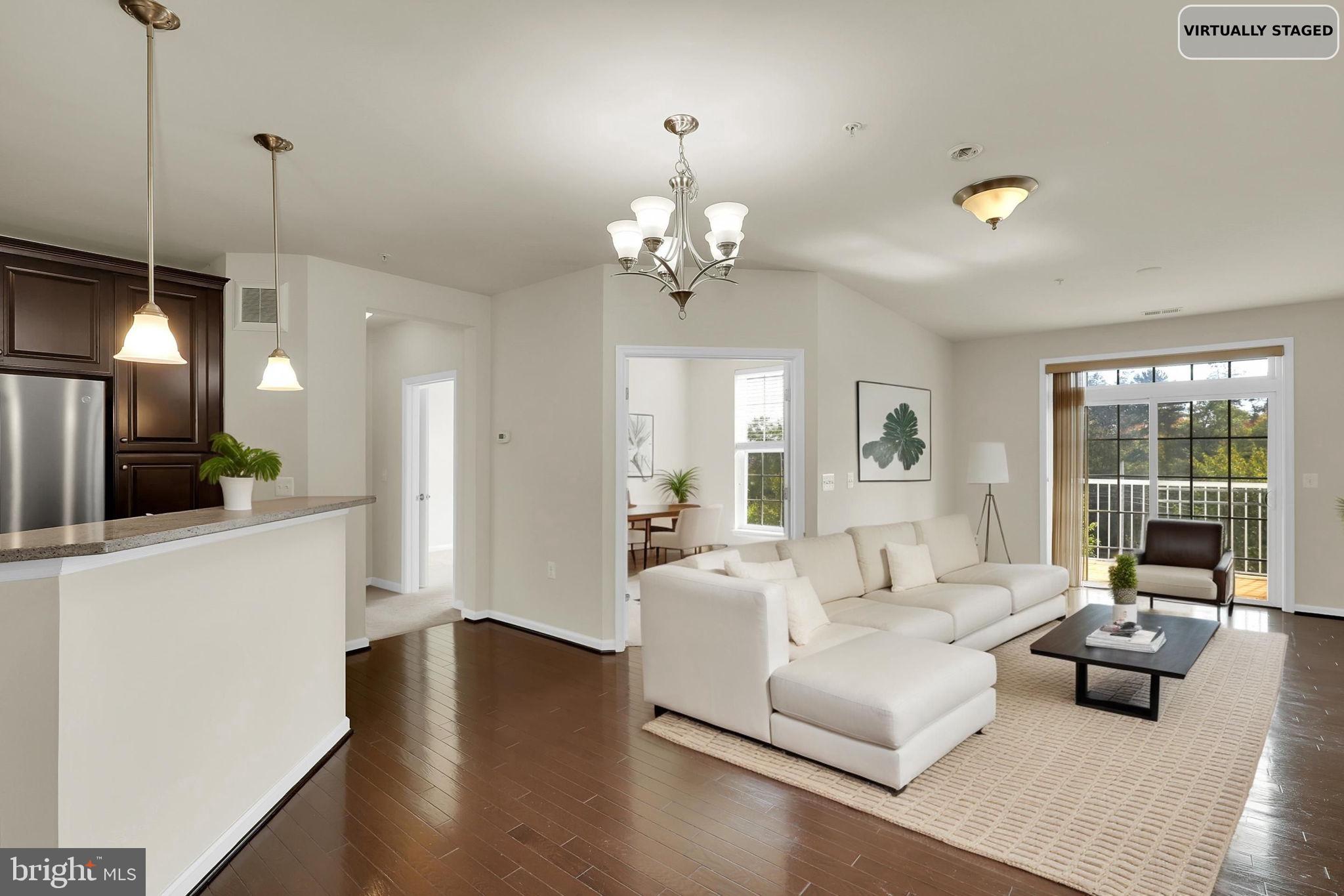 3750 Clara Downey Avenue, Unit 34 Silver Spring, MD 20906 - Photo 3 of 25 a living room with furniture a large window and a chandelier