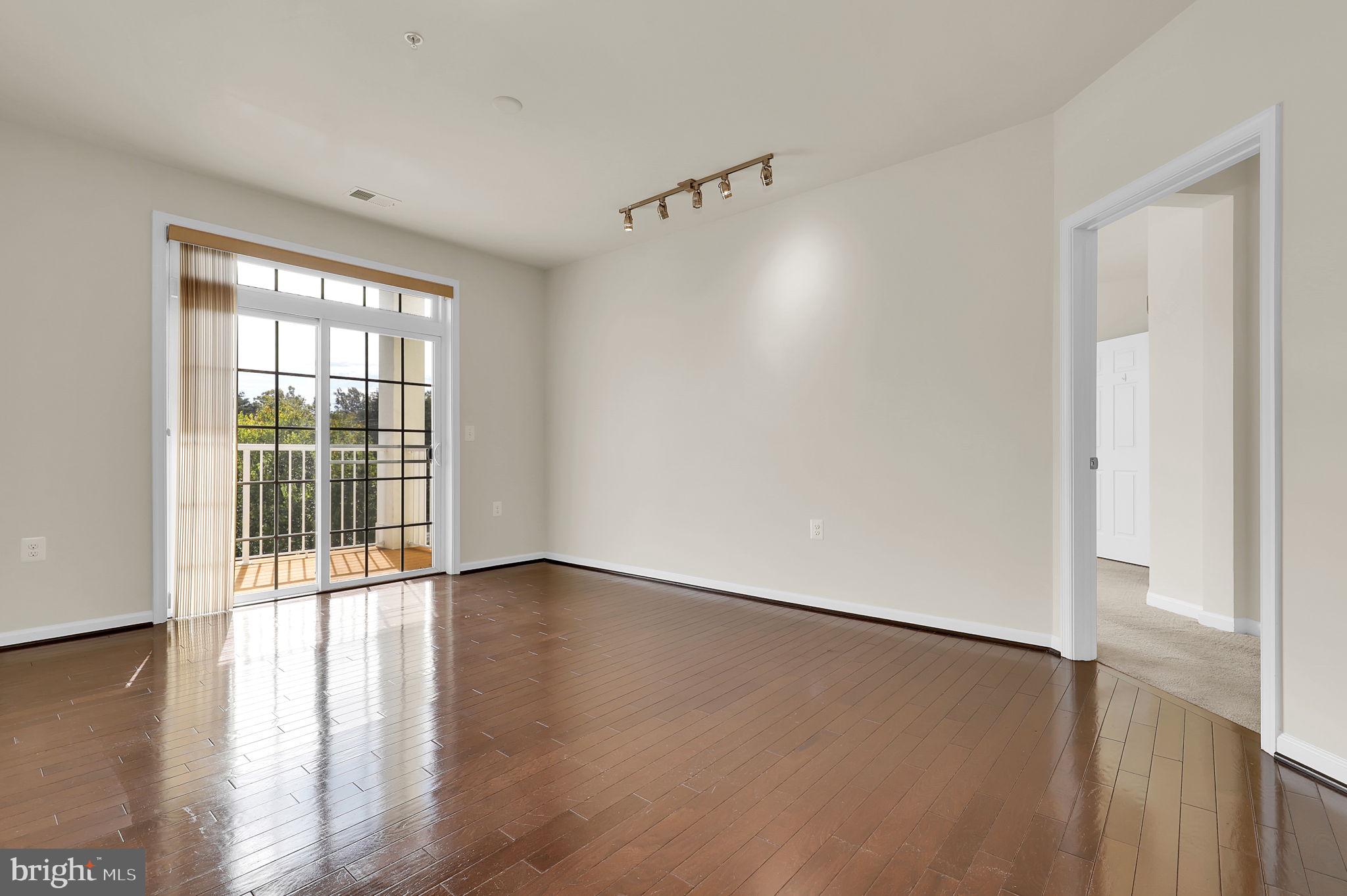 3750 Clara Downey Avenue, Unit 34 Silver Spring, MD 20906 - Photo 5 of 25 an empty room with wooden floor and windows