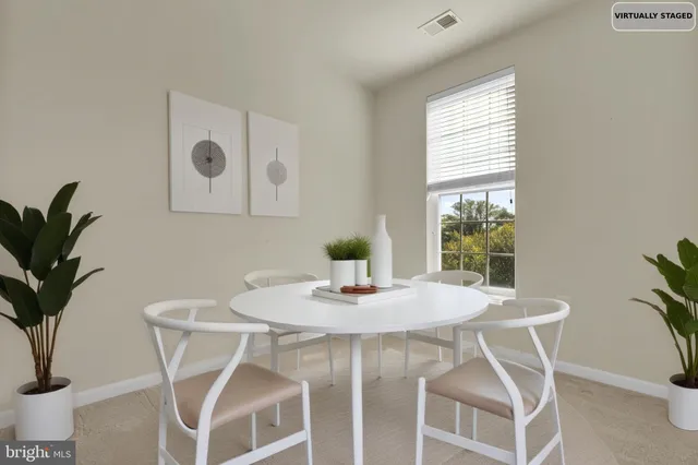 a dining room with furniture and potted plants