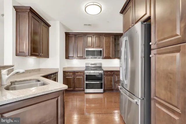 a kitchen with a refrigerator sink and stove top oven