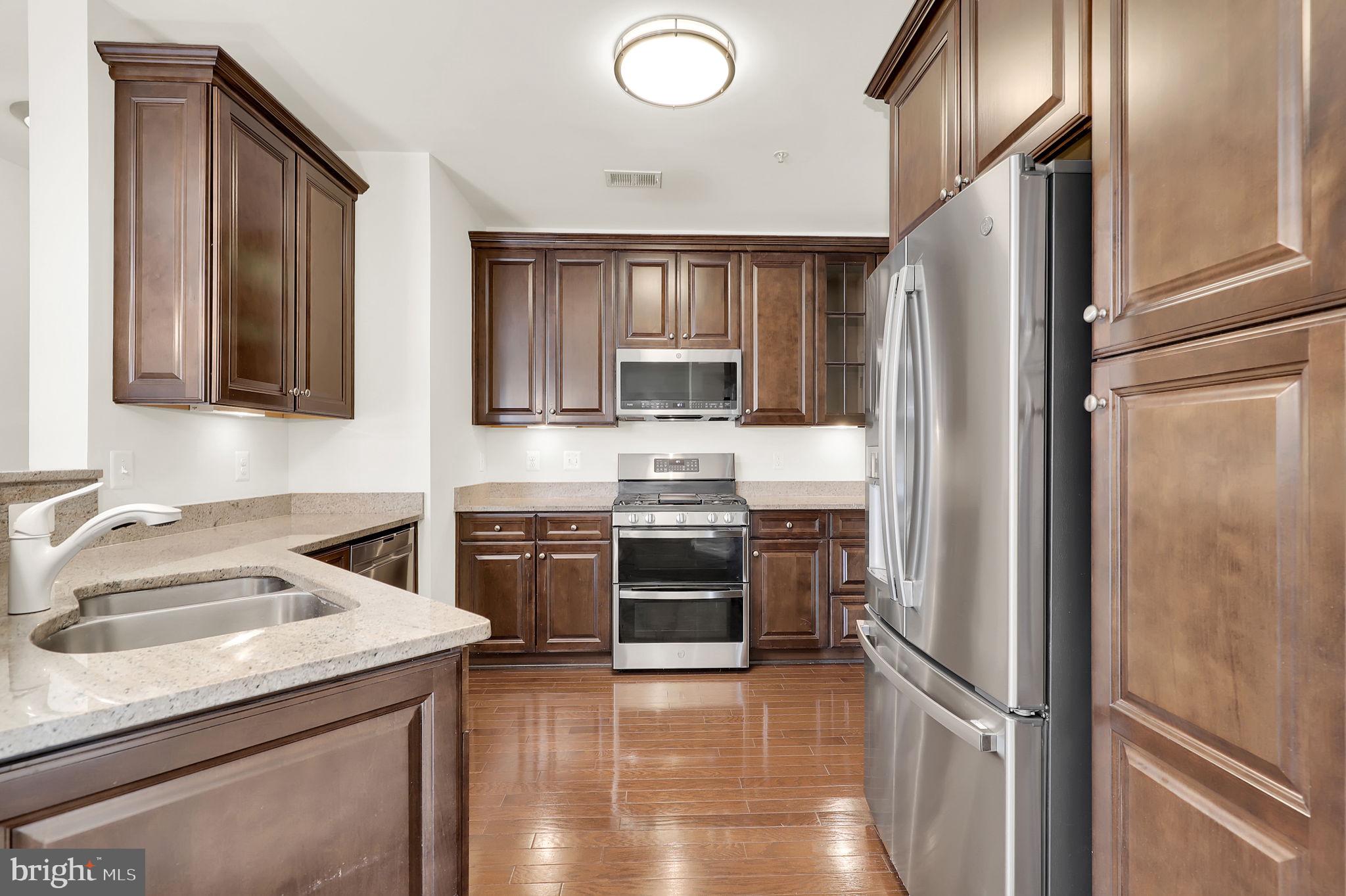 3750 Clara Downey Avenue, Unit 34 Silver Spring, MD 20906 - Photo 9 of 25 a kitchen with a refrigerator sink and stove top oven