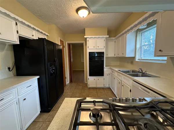 a kitchen with stainless steel appliances granite countertop a refrigerator and a stove