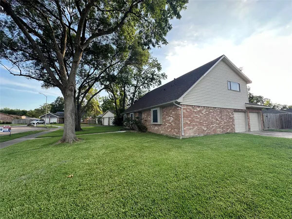 a house view with garden space and trees
