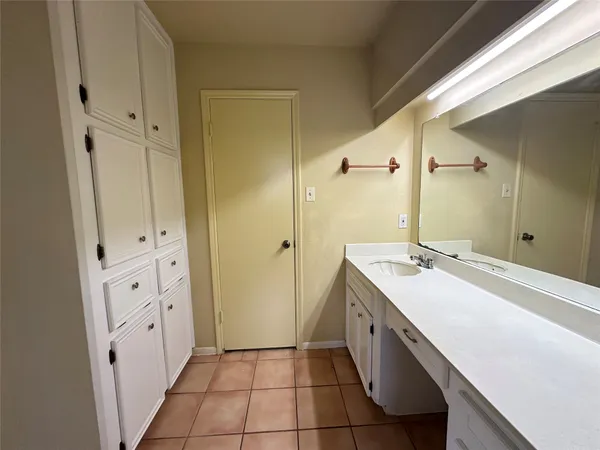 a spacious bathroom with a double vanity sink a mirror and a bathtub