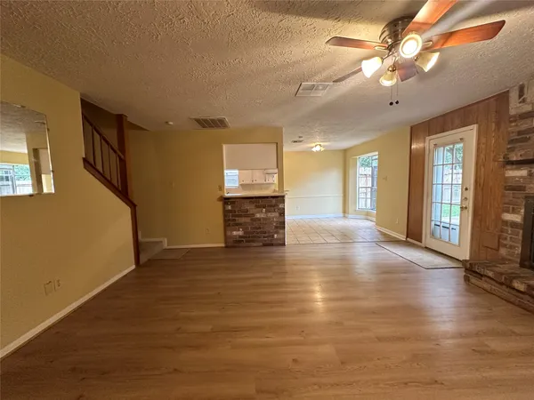 a view of an empty room with window and wooden floor