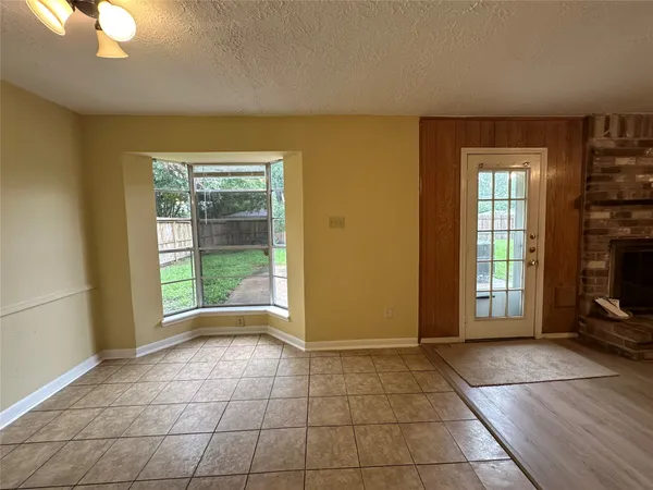 a view of an empty room with a fireplace and a window