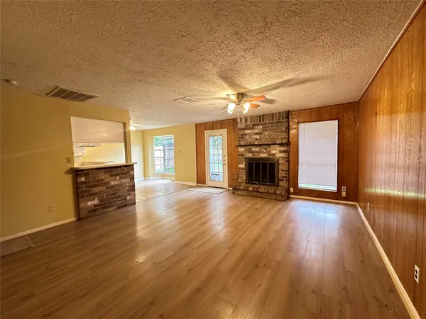 an empty room with wooden floor and fireplace