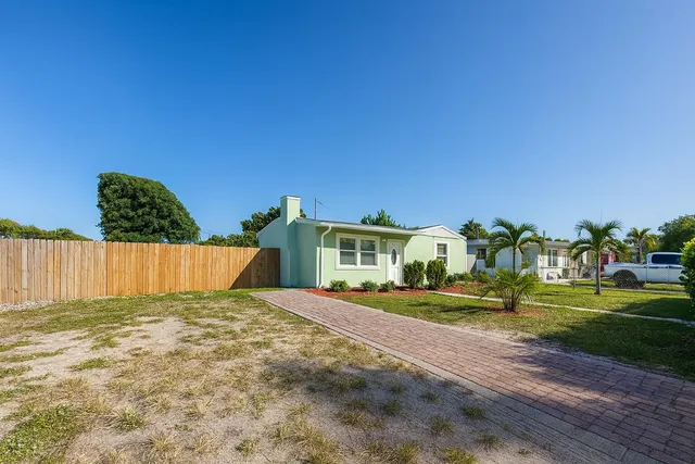 a view of an house with backyard and trees