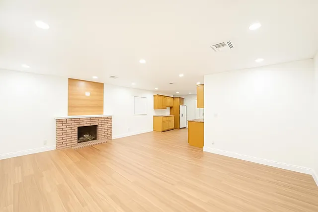 a view of an empty room with a fireplace and a window