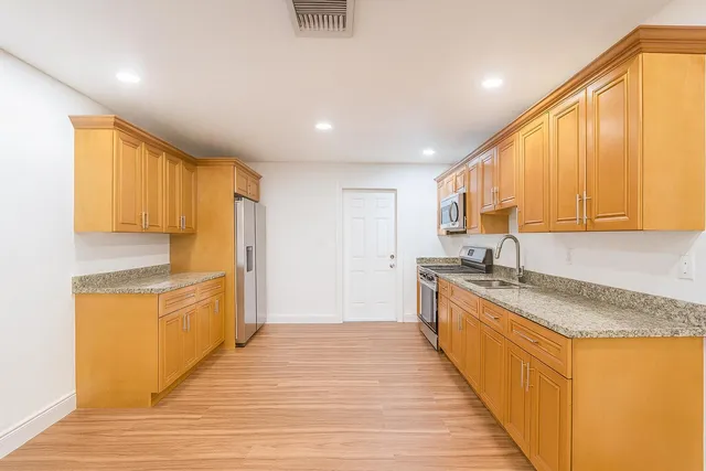 a large kitchen with stainless steel appliances granite countertop a granite counter tops and a window