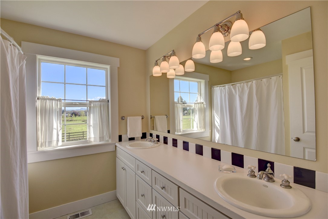 17012 Kaylen Lane Southwest Rochester, WA 98579 - Photo 15 of 26 a bathroom with a double vanity sink and a mirror
