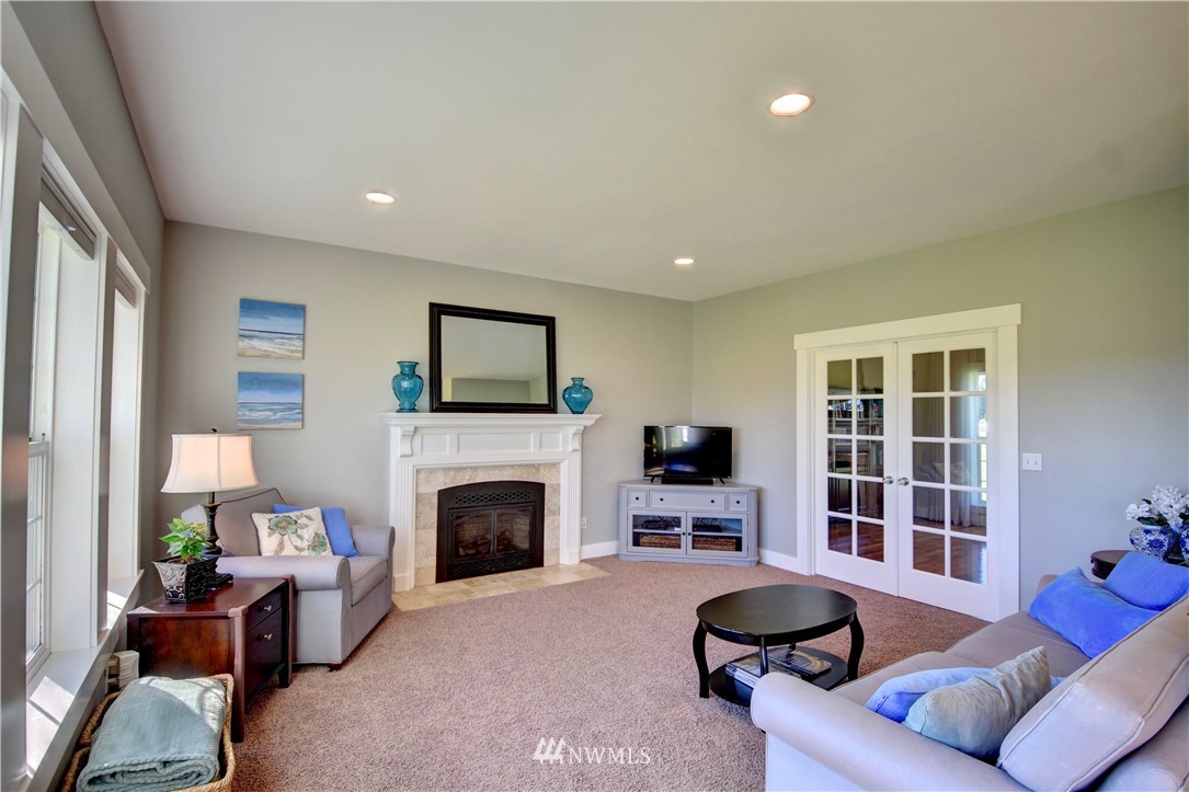 17012 Kaylen Lane Southwest Rochester, WA 98579 - Photo 3 of 26 a living room with furniture flat screen tv and a fireplace