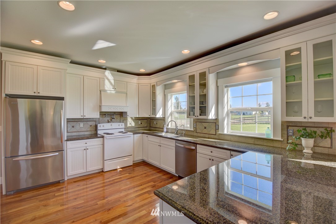 17012 Kaylen Lane Southwest Rochester, WA 98579 - Photo 6 of 26 a kitchen with stainless steel appliances granite countertop a refrigerator a sink dishwasher a stove and white countertops with wooden floor