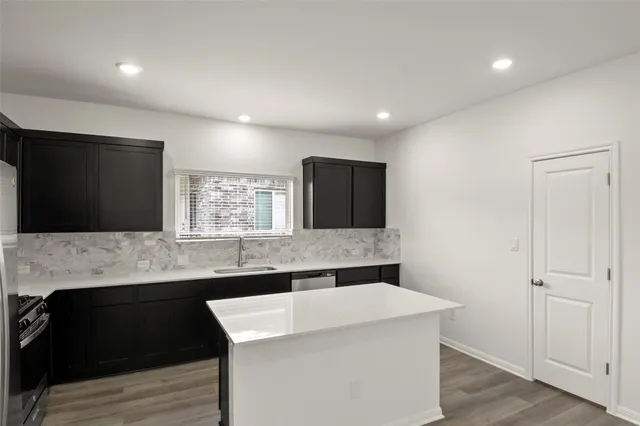 a kitchen with a sink dishwasher a stove and a refrigerator with wooden floor