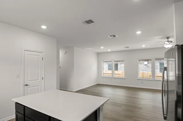 a kitchen with stainless steel appliances a sink dishwasher a refrigerator and a stove with wooden floor