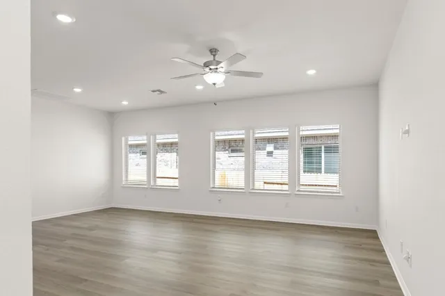 a view of empty room with window and wooden floor