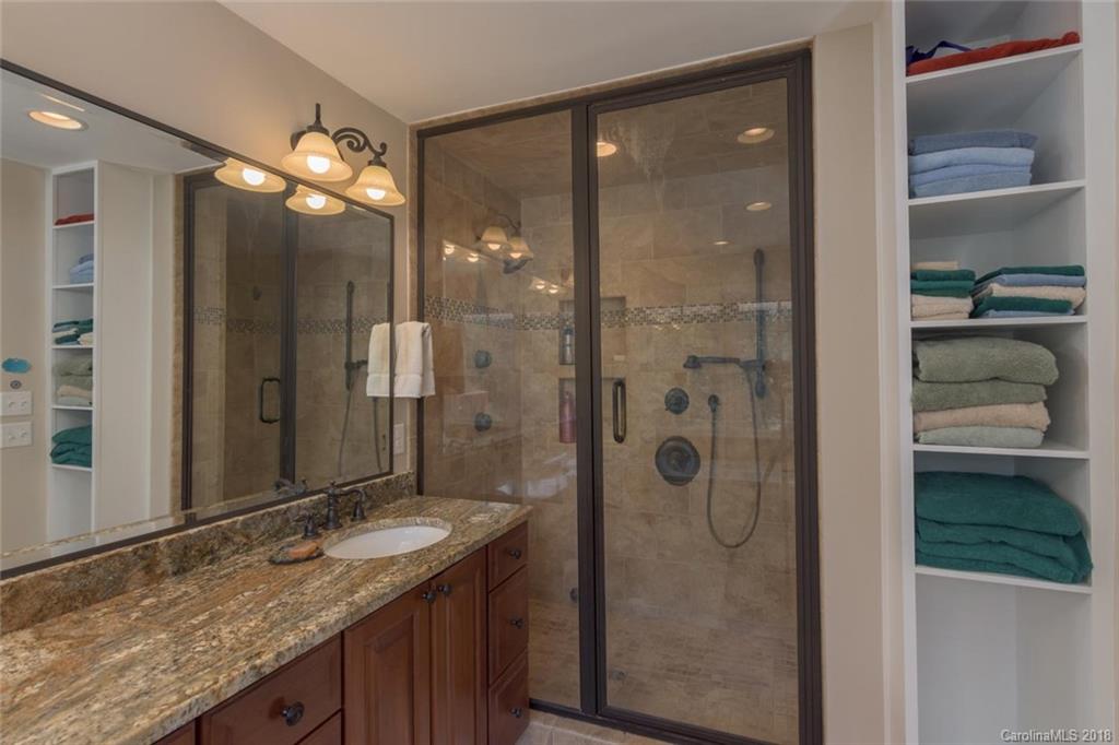 85 Forest Road Asheville, NC 28803 - Photo 18 of 39 a bathroom with a granite countertop sink mirror and shower