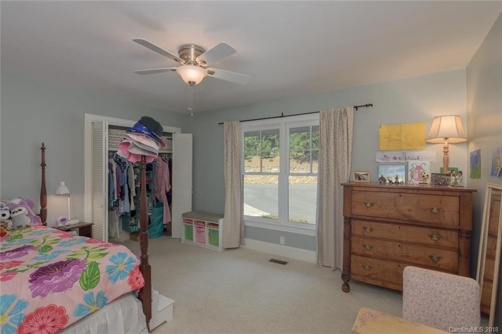 85 Forest Road Asheville, NC 28803 - Photo 19 of 39 a bedroom with a bed and a chandelier