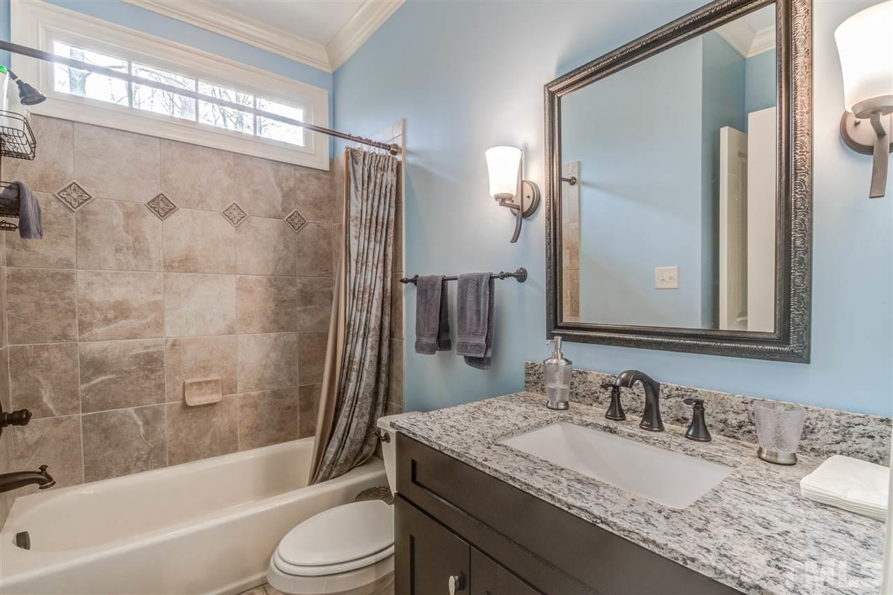 12228 Peed Road Raleigh, NC 27614 - Photo 20 of 30 a bathroom with a granite countertop sink toilet mirror and shower