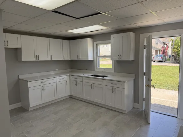 a kitchen with cabinets appliances and a window