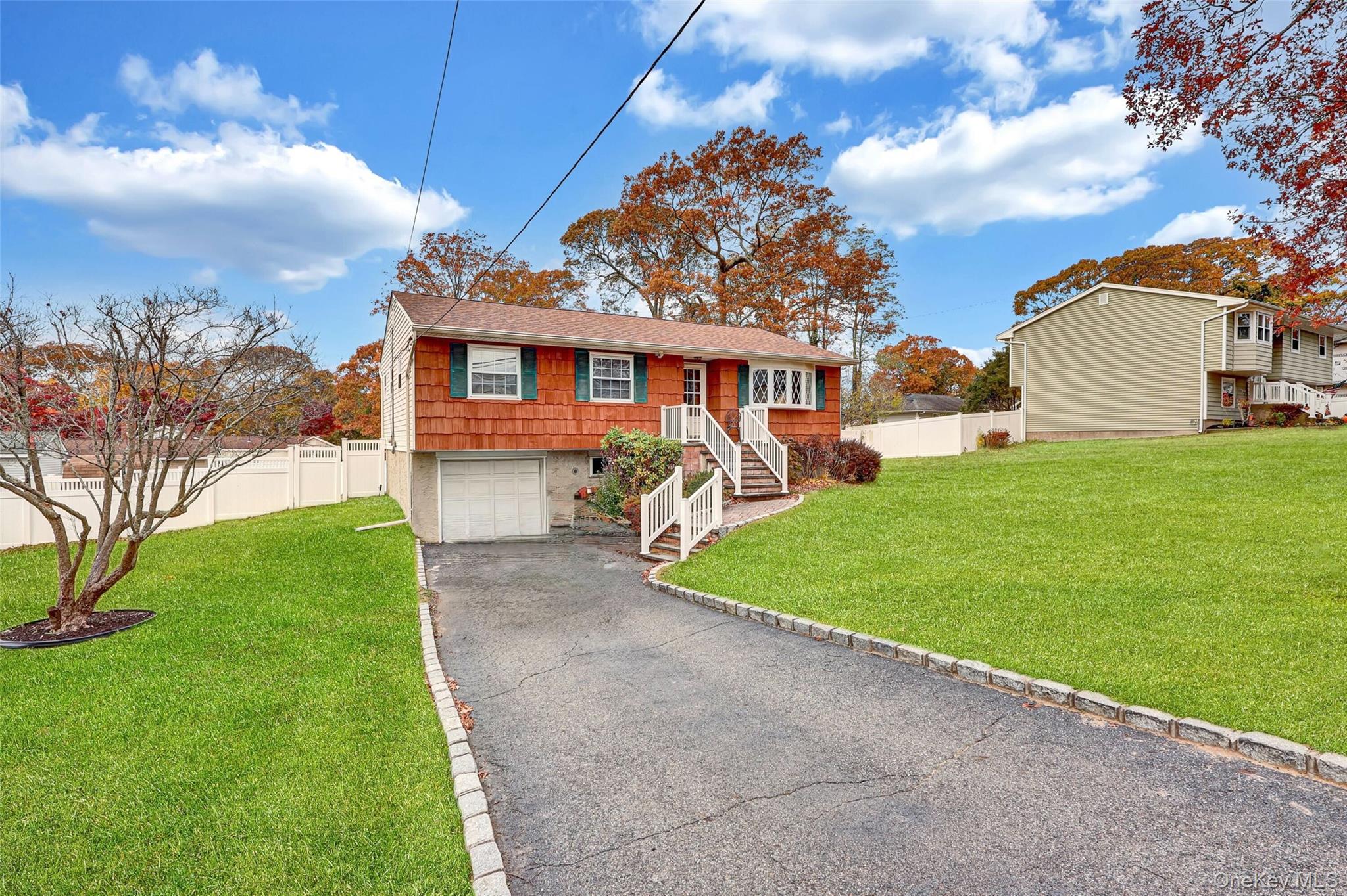 70 Blue Point Road Selden, NY 11784 - Photo 2 of 27 a front view of a house with a garden and yard