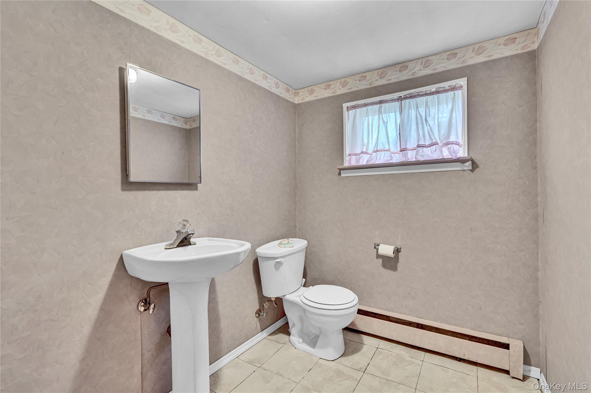 70 Blue Point Road Selden, NY 11784 - Photo 21 of 27 a bathroom with a toilet sink and mirror