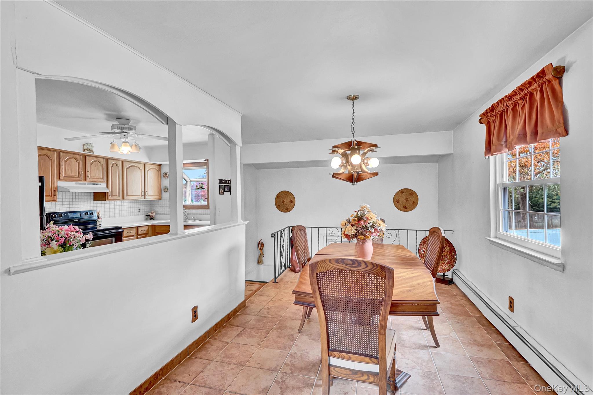 70 Blue Point Road Selden, NY 11784 - Photo 9 of 27 a dining room filled chandelier and kitchen view