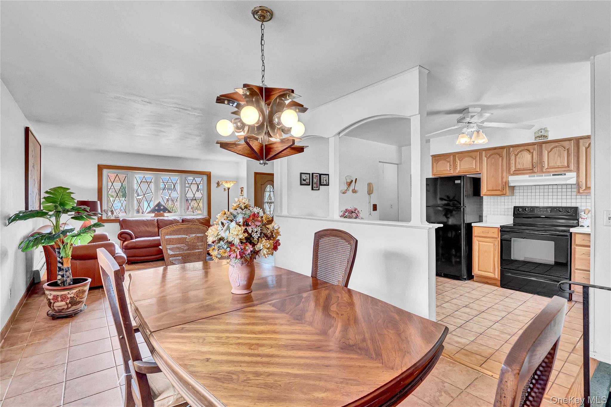 70 Blue Point Road Selden, NY 11784 - Photo 10 of 27 a view of a dining room with furniture a chandelier and wooden floor