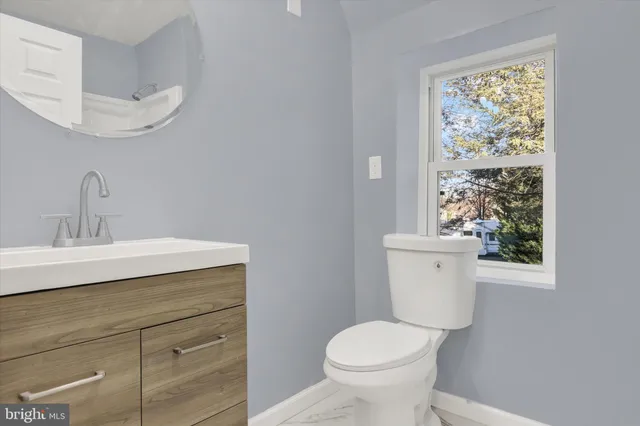 a bathroom with a toilet a sink and a window