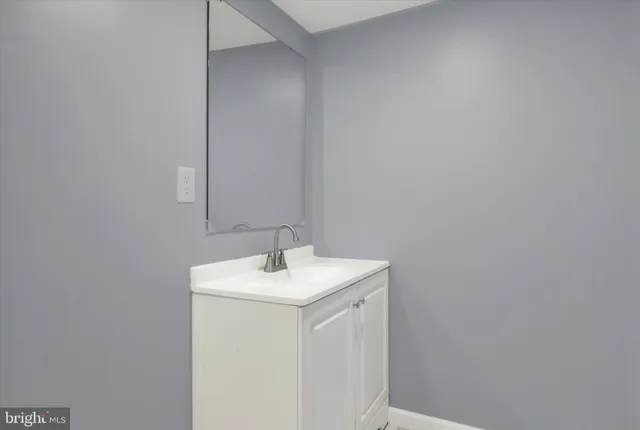 a utility room with a sink a mirror and vanity