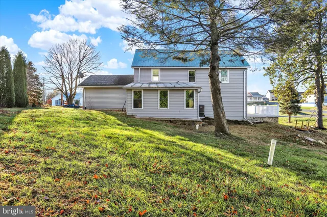 a front view of house with yard and trees around