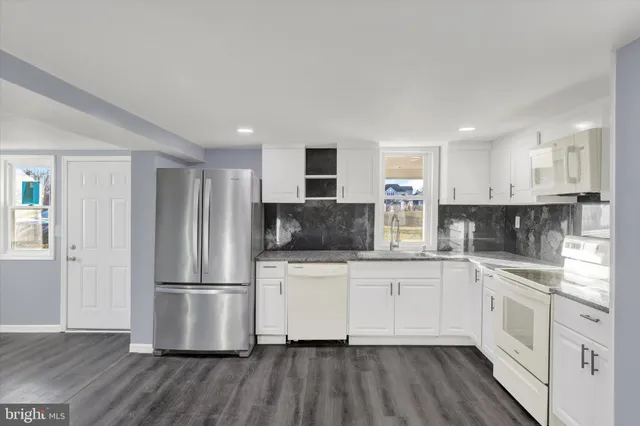 a kitchen with white cabinets and stainless steel appliances