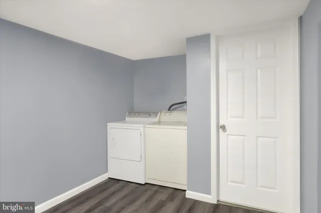 a utility room with wooden floor washer and dryer