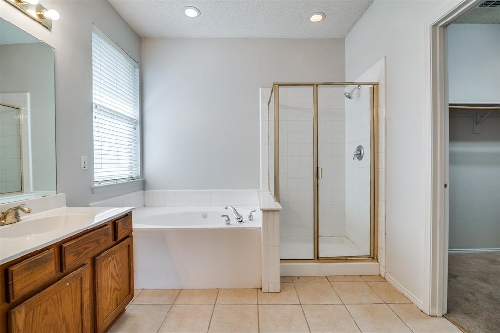 2401 Redfield Drive Mesquite, TX 75181 - Photo 13 of 25 a spacious bathroom with a bathtub sink and mirror