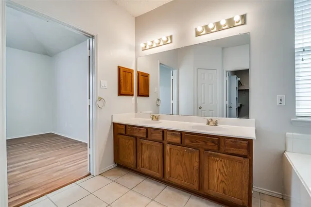 a spacious bathroom with a bathtub sink and mirror