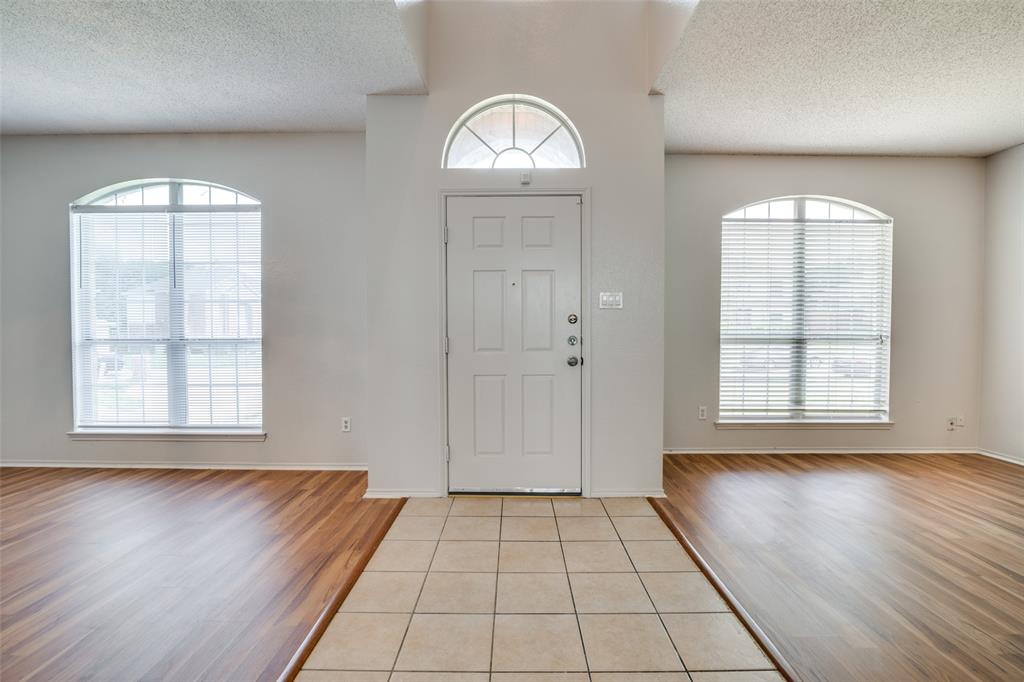 2401 Redfield Drive Mesquite, TX 75181 - Photo 2 of 25 an empty room with wooden floor cabinet and windows