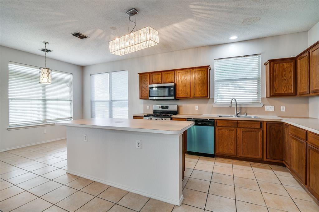 2401 Redfield Drive Mesquite, TX 75181 - Photo 7 of 25 a kitchen with stainless steel appliances granite countertop a sink counter space cabinets and a window