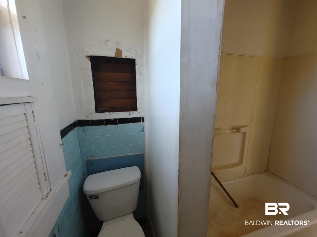 1706 Lomeroy Street Mobile, AL 36604 - Photo 11 of 24 Full bath featuring a wainscoted wall, tile walls, toilet, and a bath