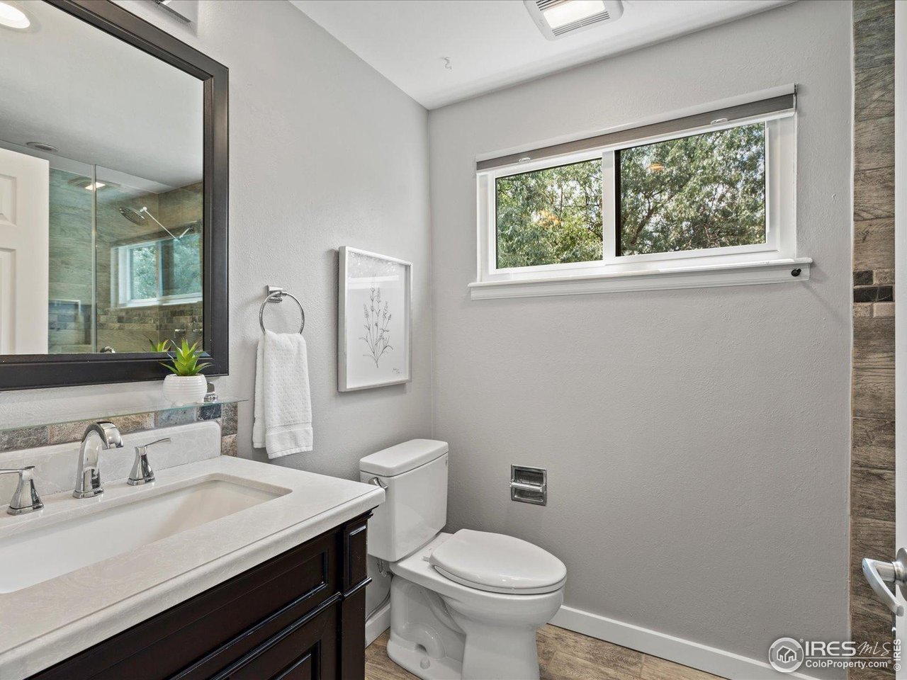 7466 Old Post Road Boulder, CO 80301 - Photo 24 of 36 a bathroom with a granite countertop sink vanity mirror and toilet