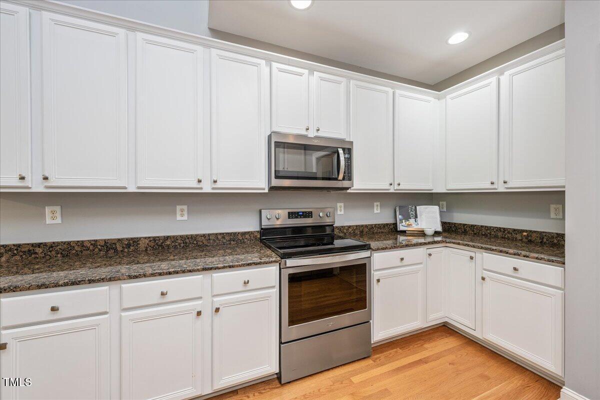 714 Continental Drive Durham, NC 27712 - Photo 13 of 34 a kitchen with granite countertop white cabinets white stainless steel appliances with a sink and dishwasher