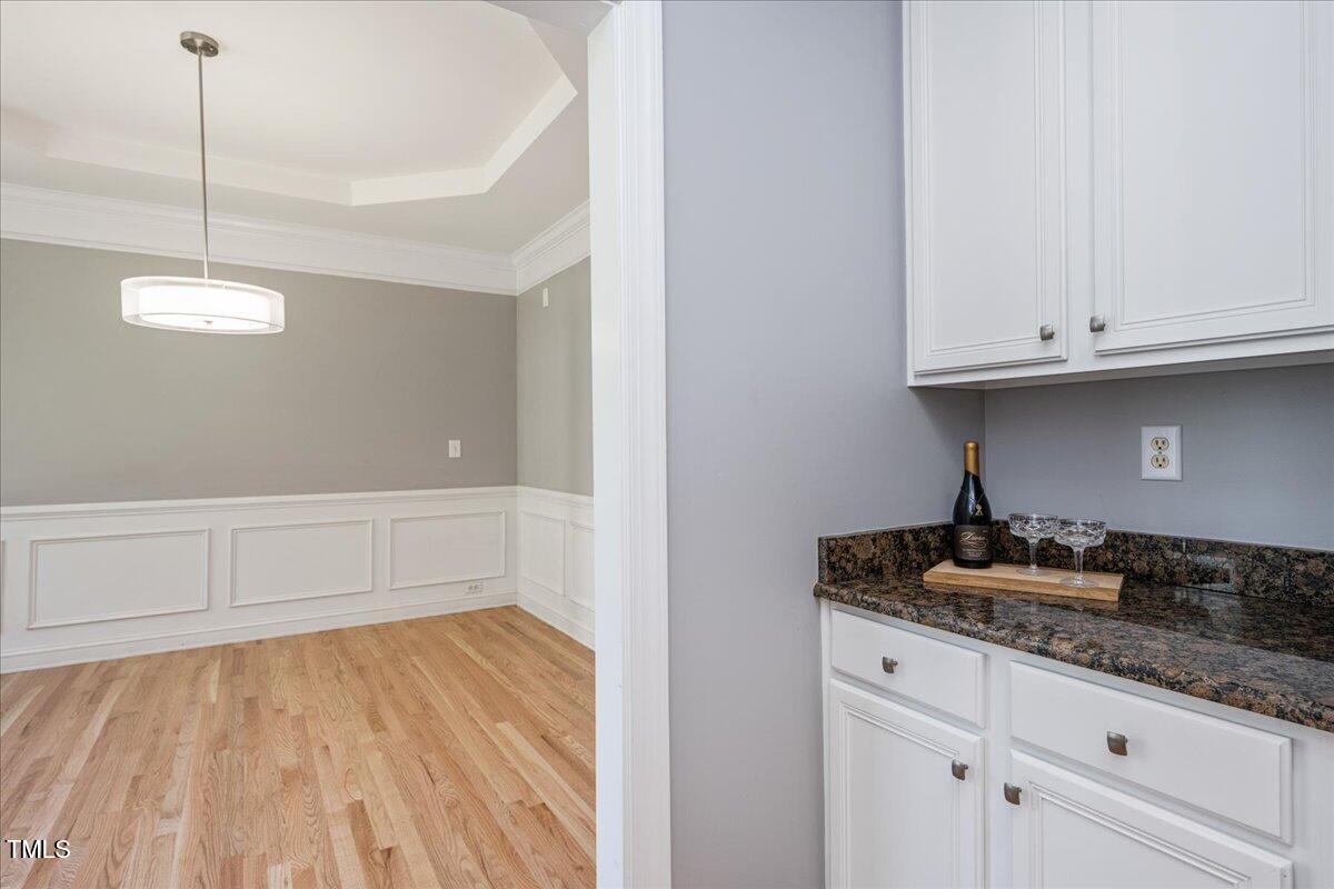 714 Continental Drive Durham, NC 27712 - Photo 15 of 34 a kitchen with granite countertop white cabinets and a wooden floor