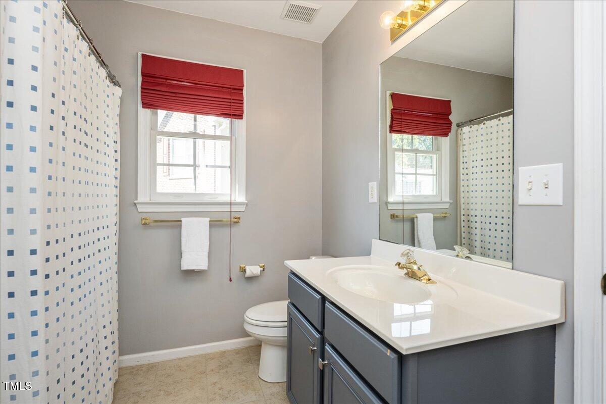 714 Continental Drive Durham, NC 27712 - Photo 24 of 34 a bathroom with a sink toilet and window