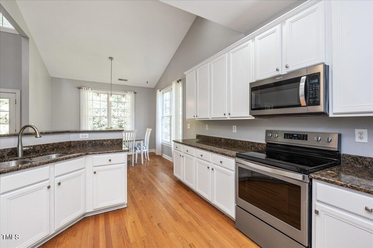 714 Continental Drive Durham, NC 27712 - Photo 3 of 34 a kitchen with stainless steel appliances granite countertop a stove a sink and a microwave