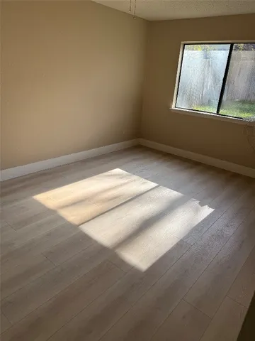a view of room with window and wooden floor