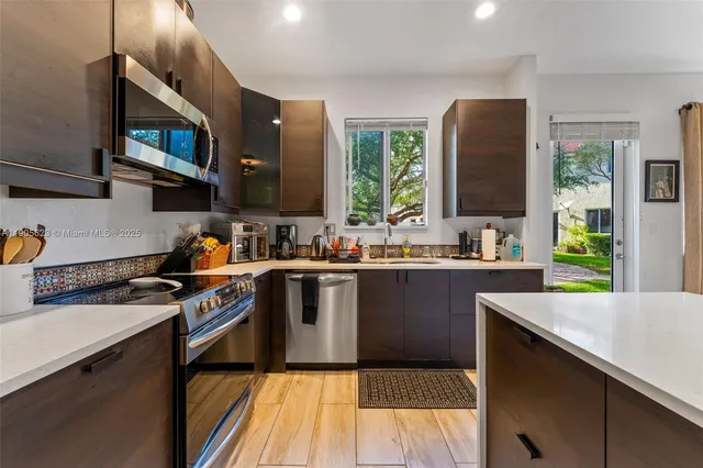 a kitchen with stainless steel appliances granite countertop a stove a sink and a microwave