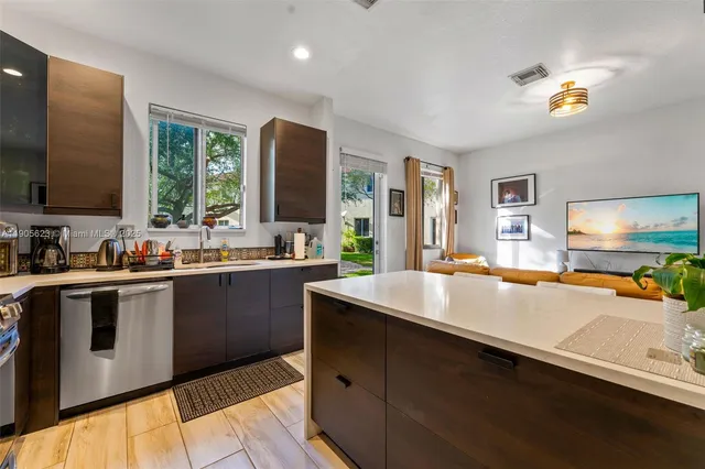 a kitchen with stainless steel appliances a sink dishwasher stove and oven