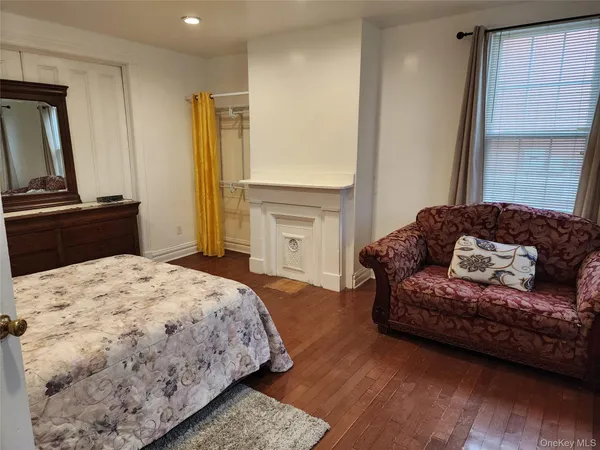a bedroom with a bed window and dresser