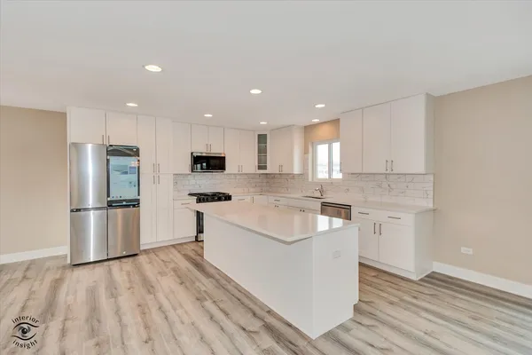 a large kitchen with a sink and refrigerator