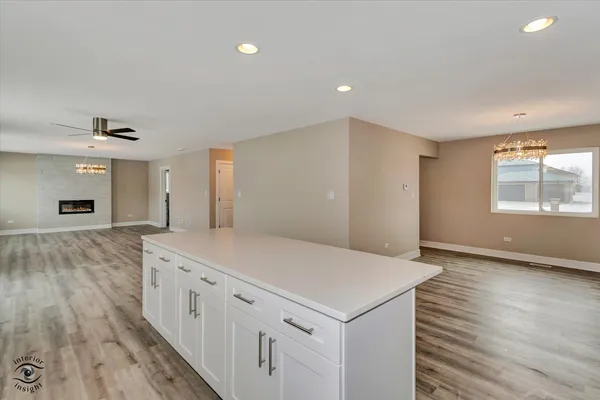 an empty room with wooden floor cabinet and windows